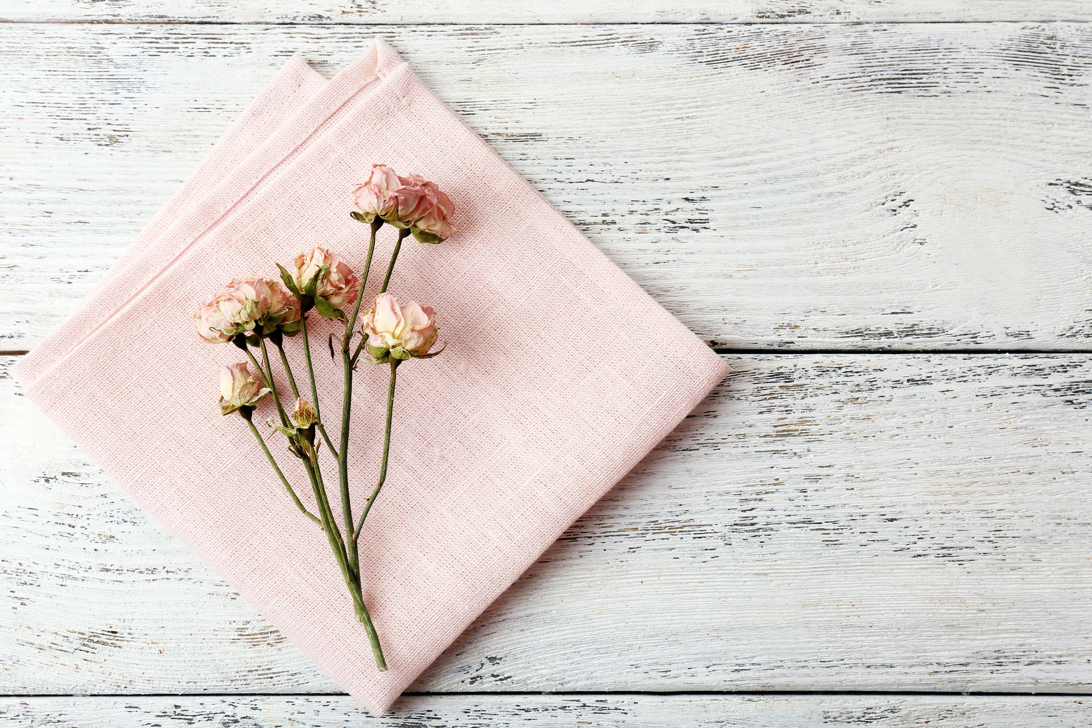 Beautiful Dry Flowers on Napkin on Wooden Background